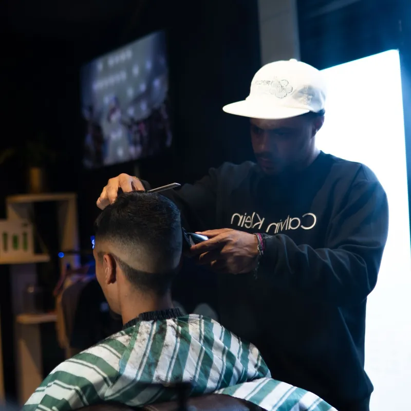 The barber combing through a client's hair before the cut