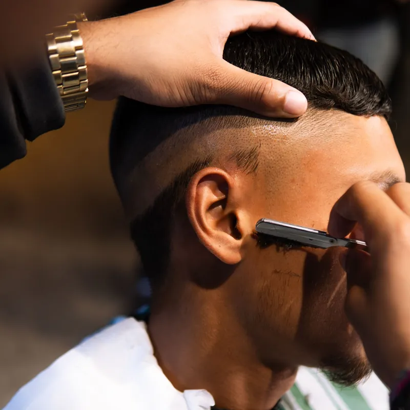 A straight razor lining up the edge behind the ear