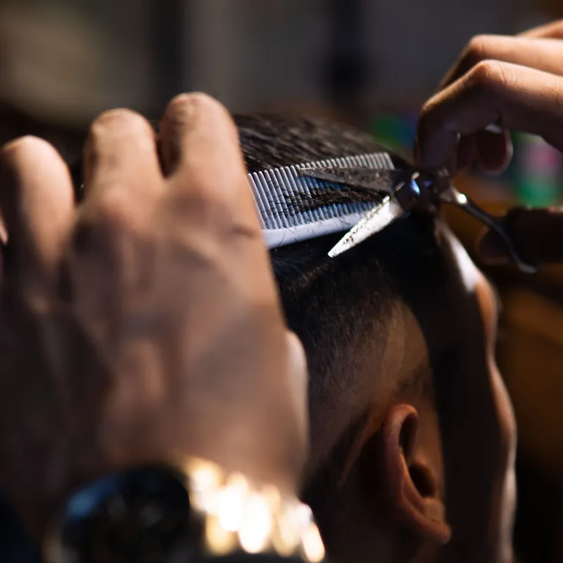 Scissors cutting over a comb on top