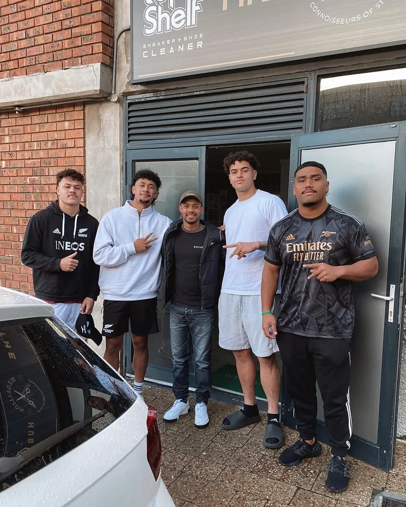 New Zealand under-20 rugby players outside The Medallion's shopfront in Cape Town